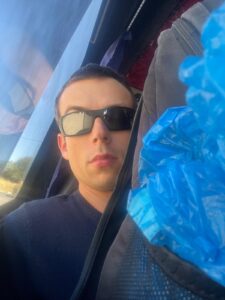 Alex with bags stacked up to his face on a shared minivan in Botswana.