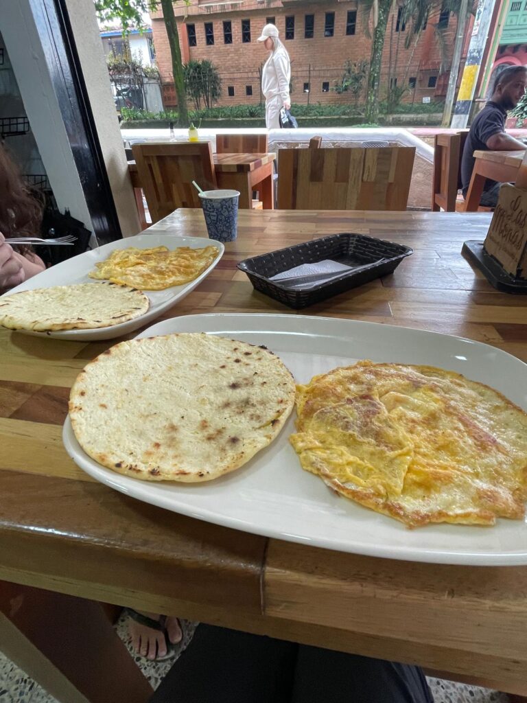 Two breakfasts consisting of an arepa and an omelette in Medellin, Colombia.