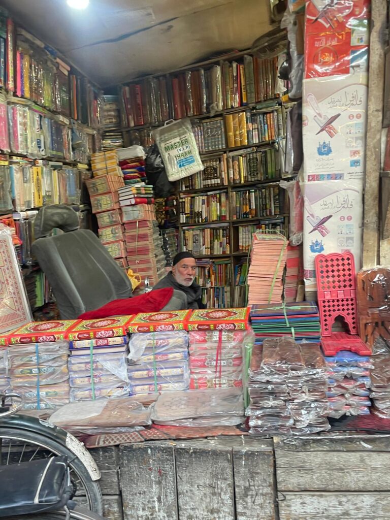 A man sitting inside his book stall at a market in Kabul, Afghanistan.