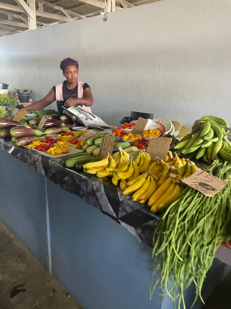 A lady selling fruit including several bananas at Paramaribo's Central Market in Suriname.