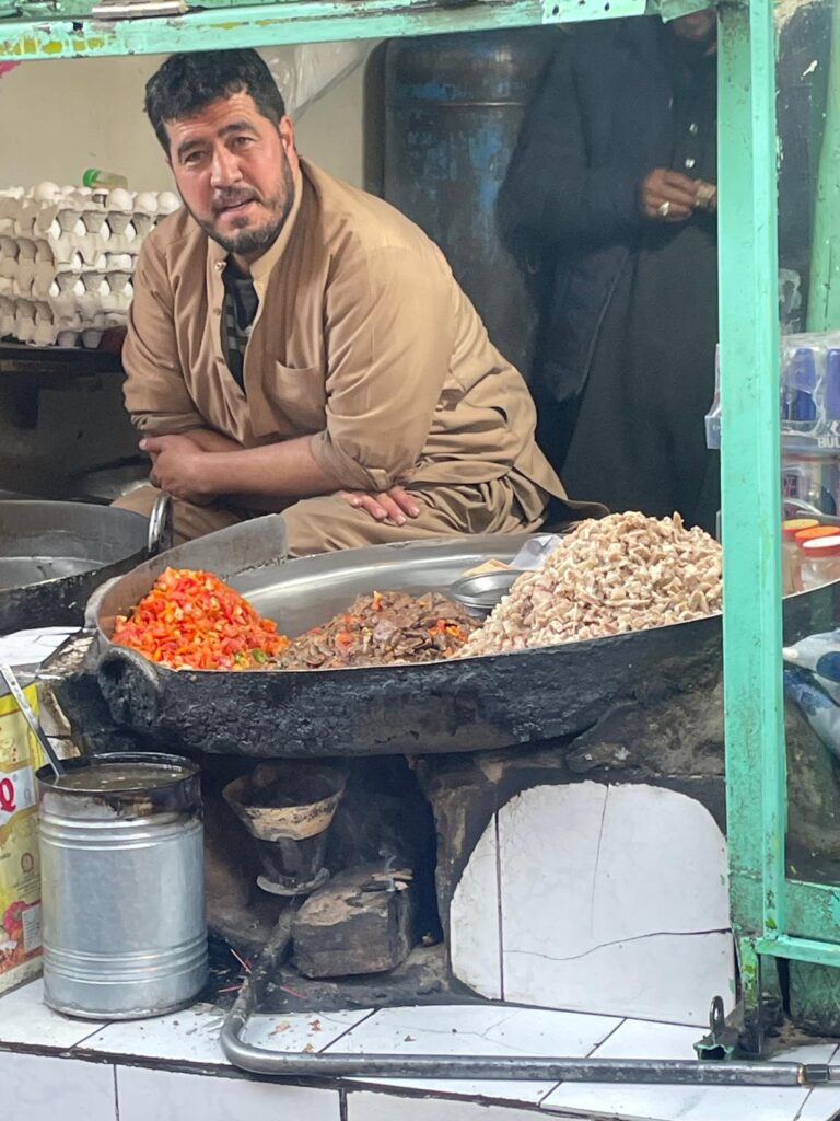 A man selling food at a street stall in Kabul, Afghanistan.