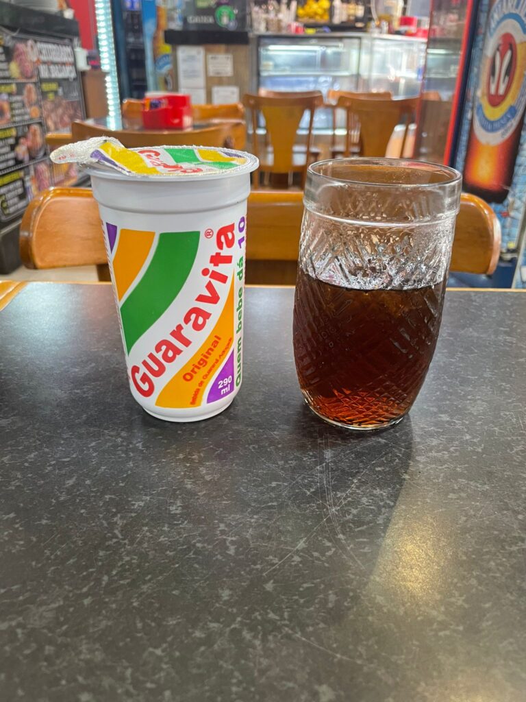 A plastic Guaravita cup alongside a glass full of the brown-coloured drink, made from the Guarana fruit and exclusive to the Rio de Janeiro area.