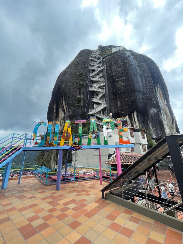 A colourful "Guatape" sign in front of El Peñón de Guatapé. 