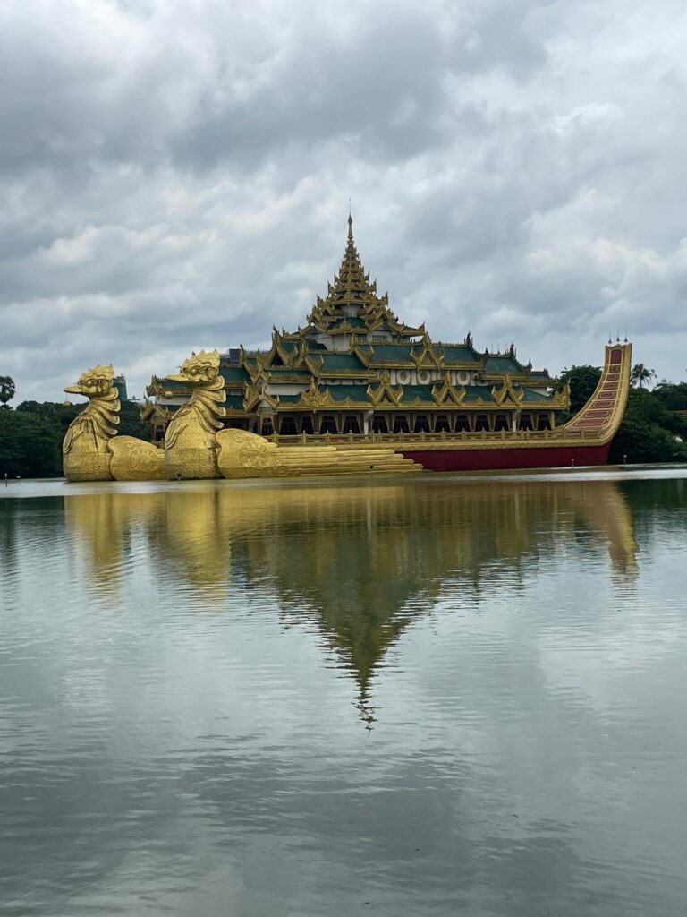 Karaweik Palace on Yangon's Kandawgyi Lake. It has two gold dragon statues at the front, and lies on the water of the lake.