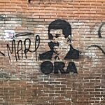 A graffiti image of Venezuelan president Nicolas Maduro in Caracas, with the word "ora" written underneath.