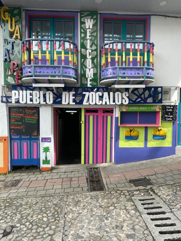 A colourful building in Guatape town, Colombia, that says "Pueblo de Zocalos" on the front.