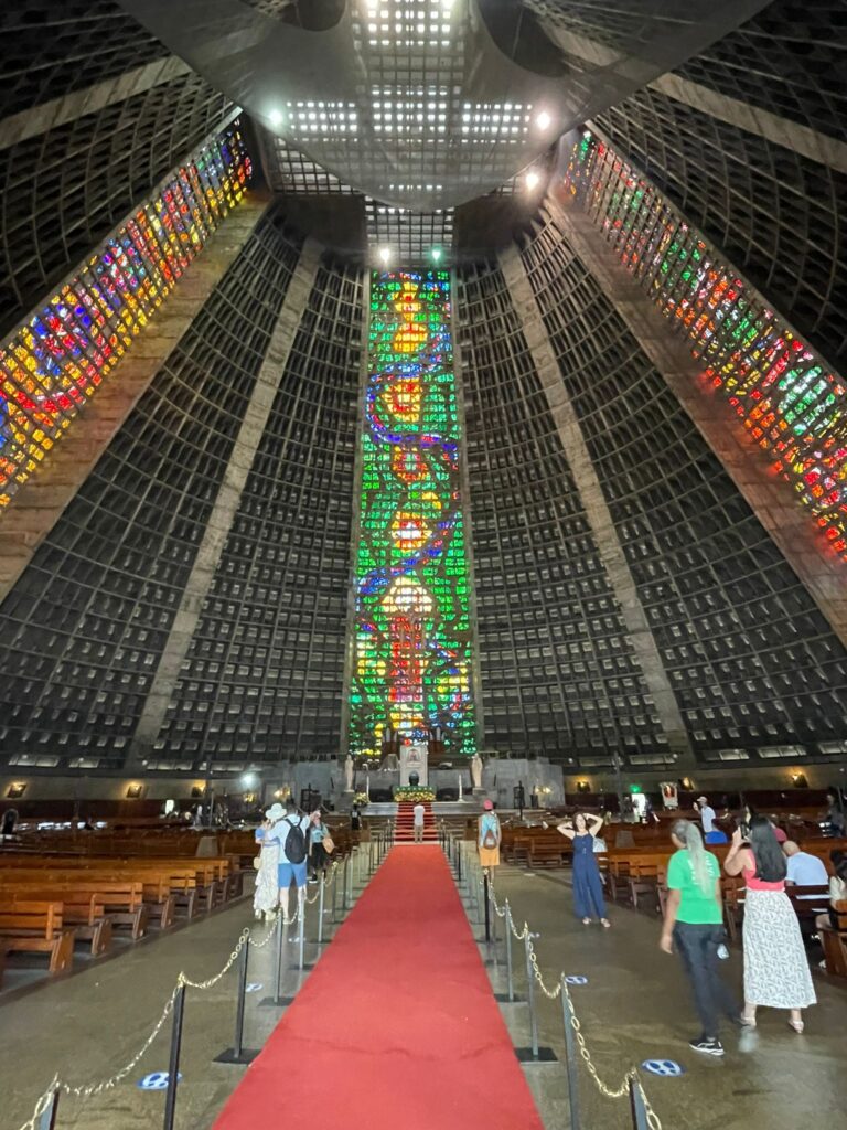 Inside the cone-shaped Metropolitan Cathedral of Saint Sebastian in Rio de Janeiro. You can see several columns of stained glass windows in the building.