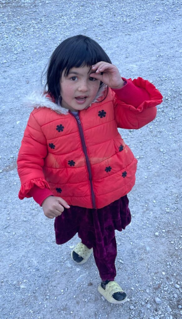 A young Tajik girl in a red jacket.