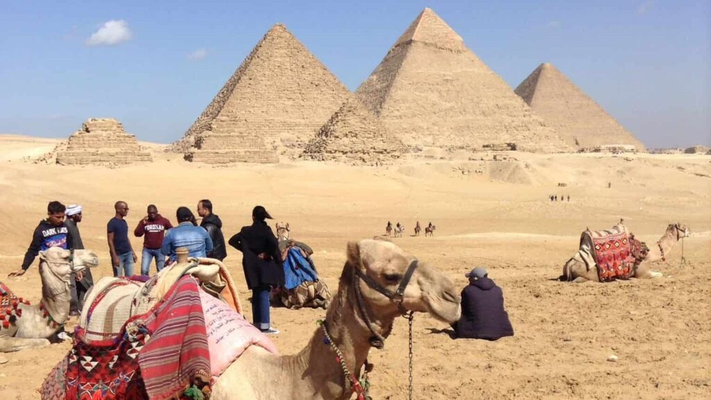 The Great Pyramids of Giza with a camel and some locals in the foreground