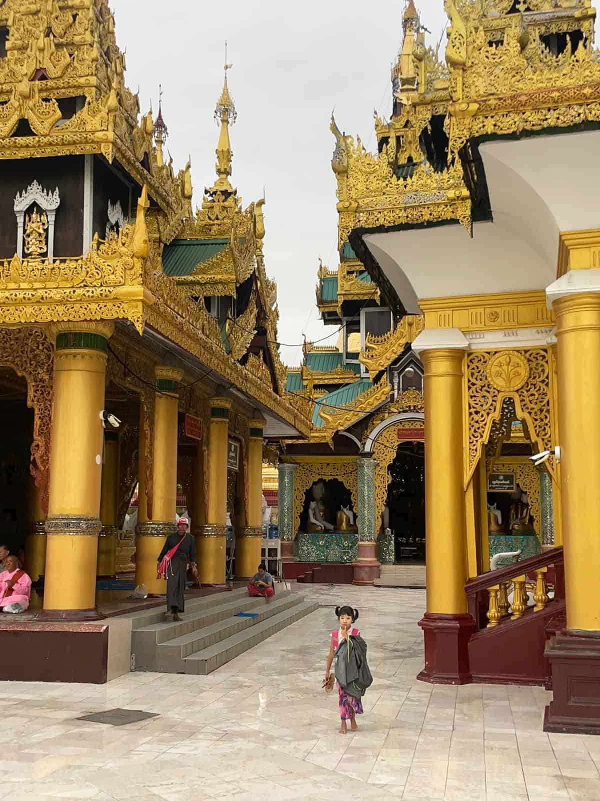 A young Buddhist girl standing at Shwedagon Pagoda in Yangon, Myanmar