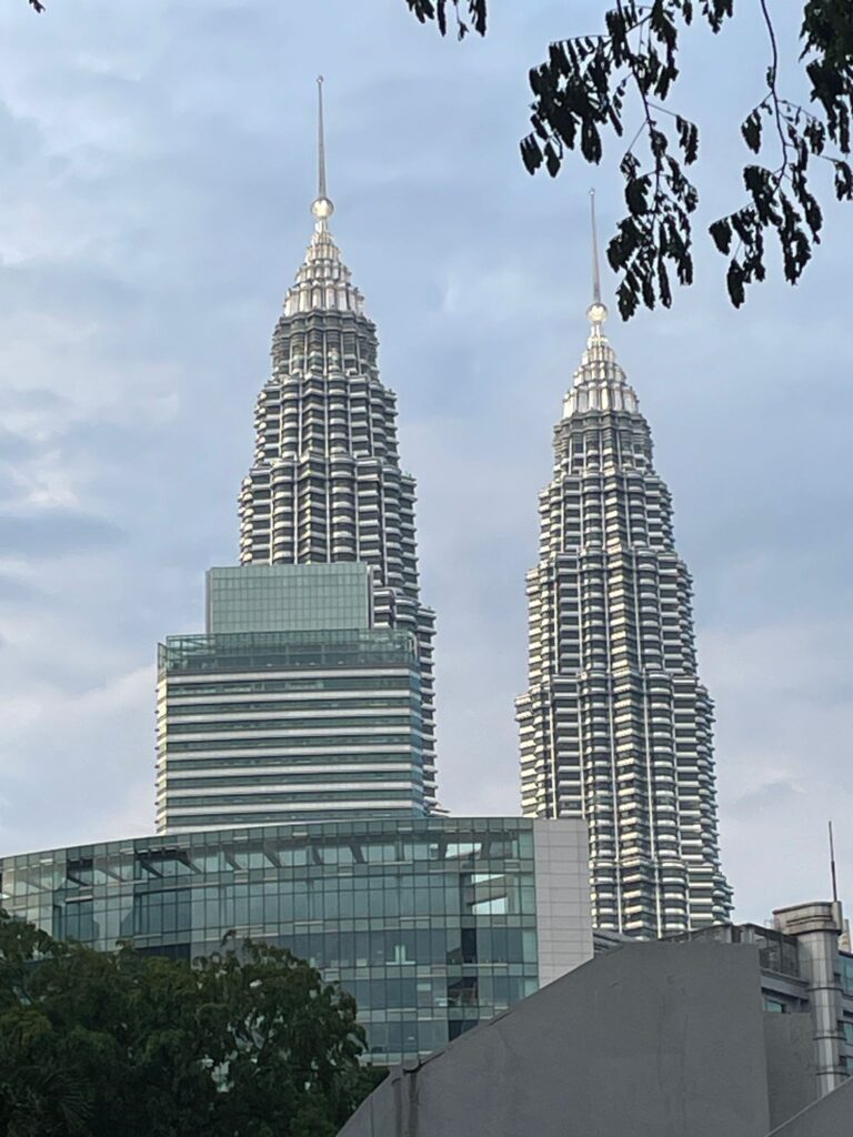 The iconic Petronas Towers in Kuala Lumpur, Malaysia poking up above the surrounding buildings