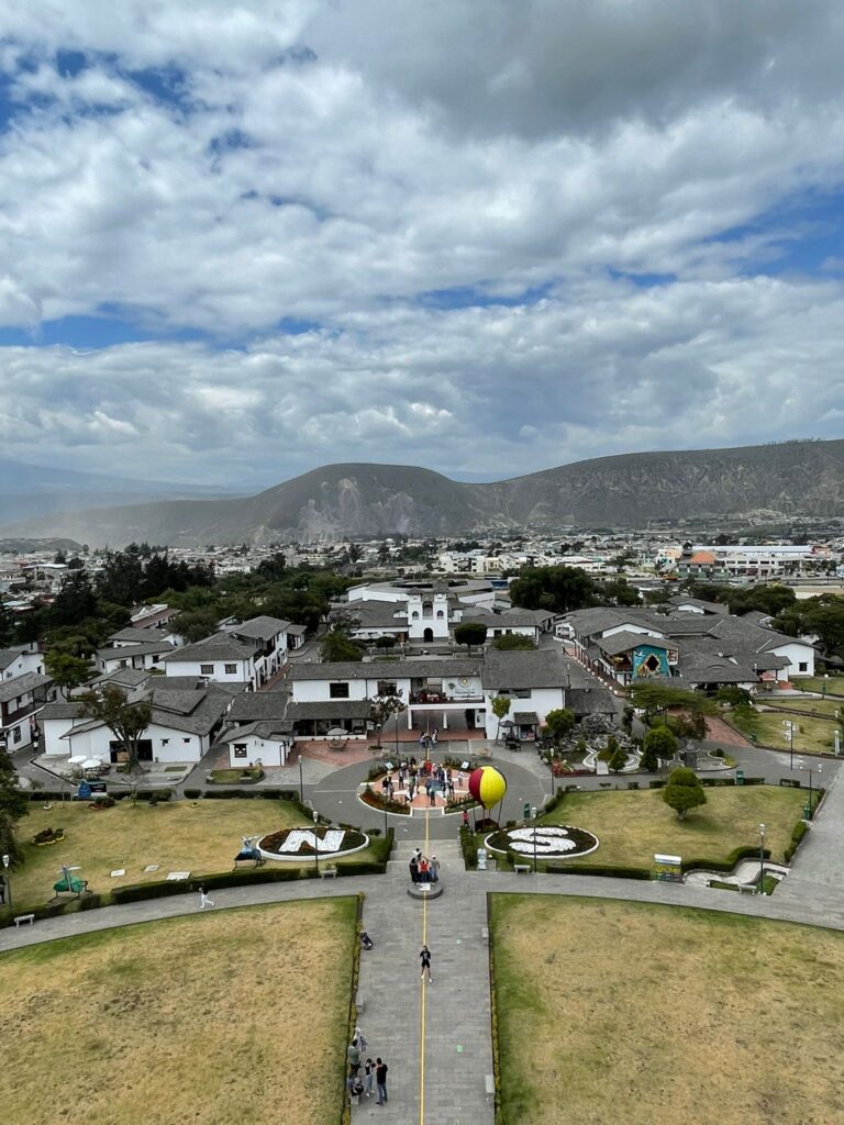 Views of the surrounding buildings and mountains from the top of the Mitad del Mundo monument in Quito, Ecuador.