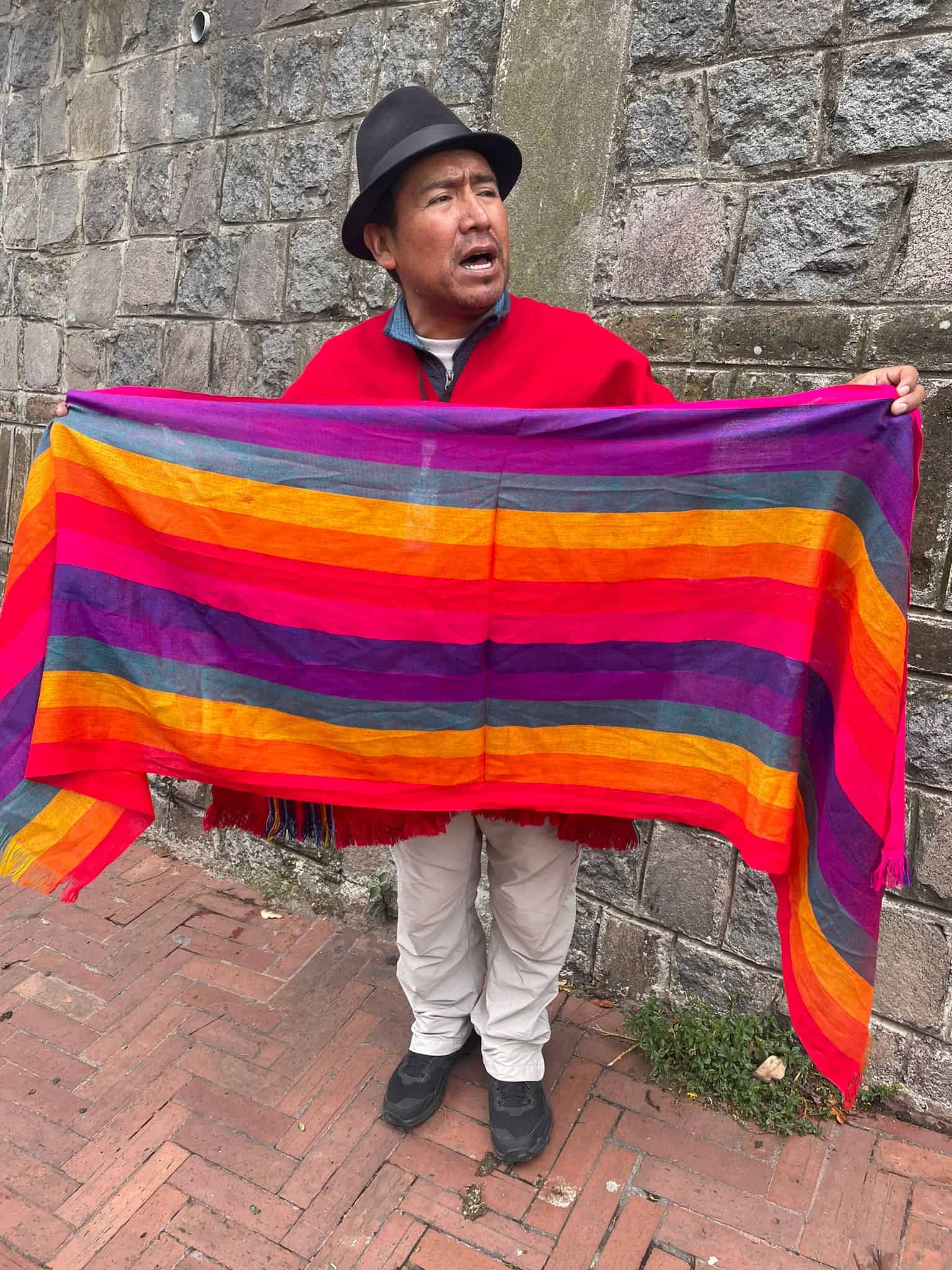 A man in Quito, Ecuador, holding an indigenous scarf.
