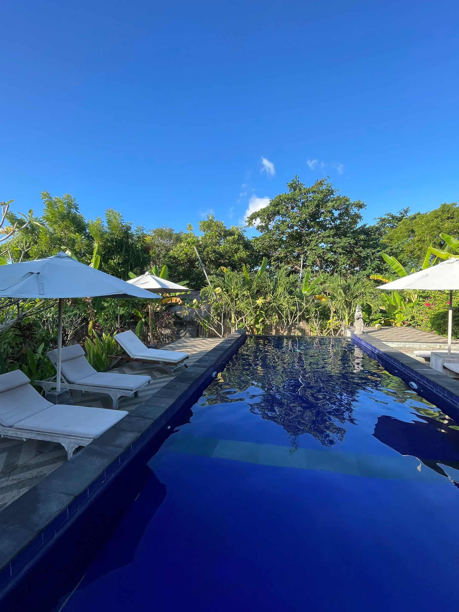 A swimming pool surrounded by sun loungers in Nusa Lembongan, Bali, Indonesia.