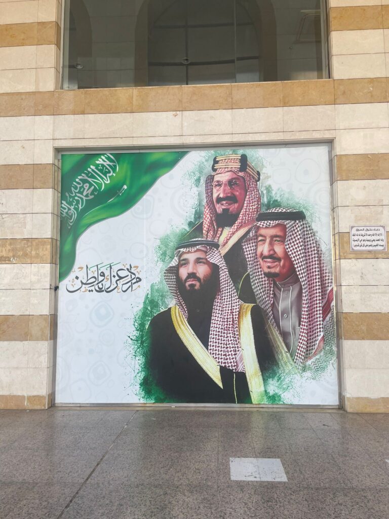 A picture in Medina which shows three Saudi royals dressed in the traditional Saudi clothing, alongside a picture of the nation's flag