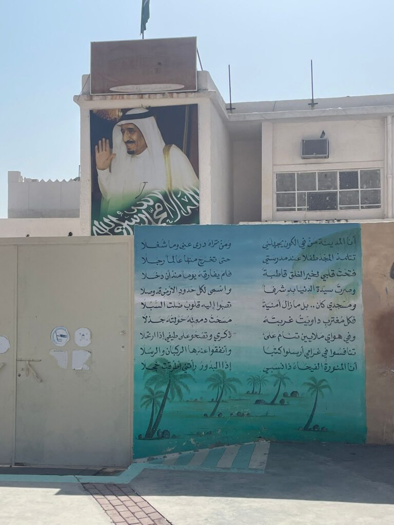 This picture shows a Saudi man in a traditional thobe on a building which can be found at the base of Mount Uhud