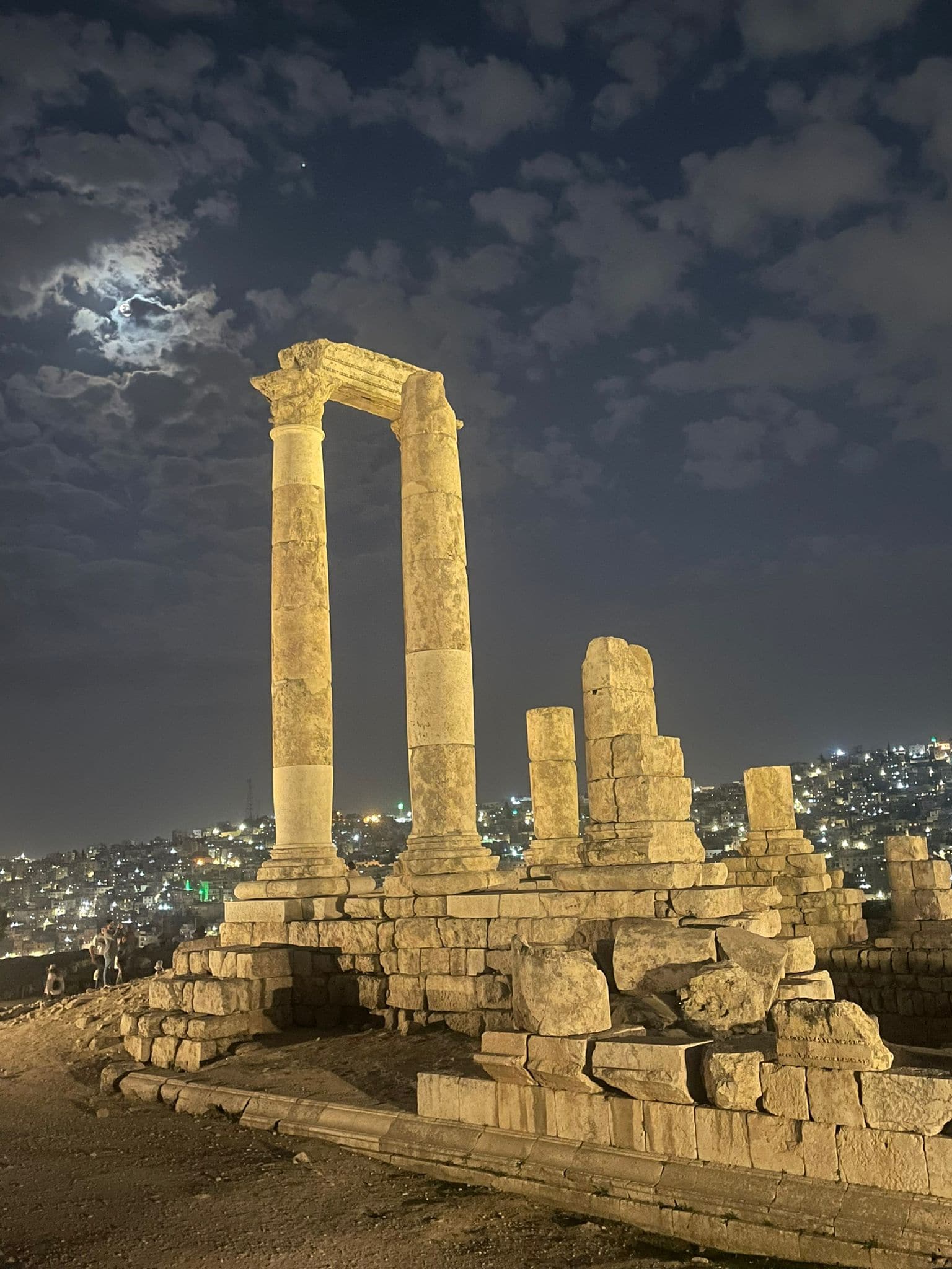 The Temple of Hercules at Amman Citadel with the city lights and moonlight in the background creating a stunning backdrop shortly after the sun had set