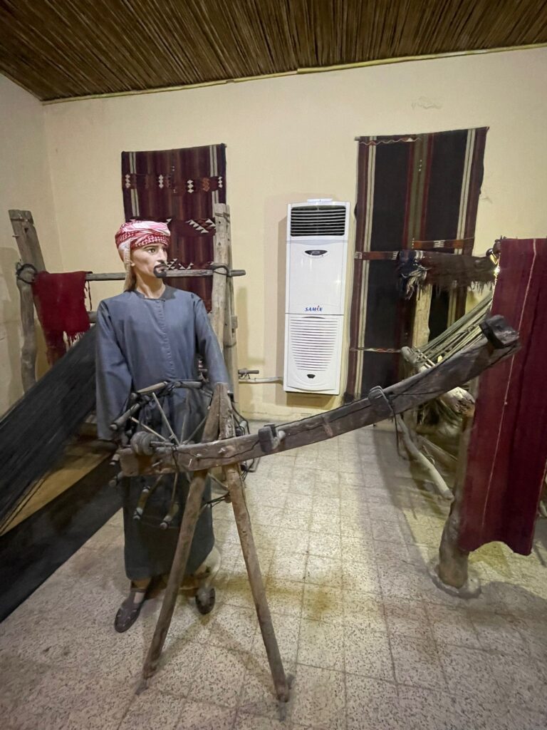 A model of a Jordanian man in traditional clothing at the Folklore Museum, working on some textiles. 