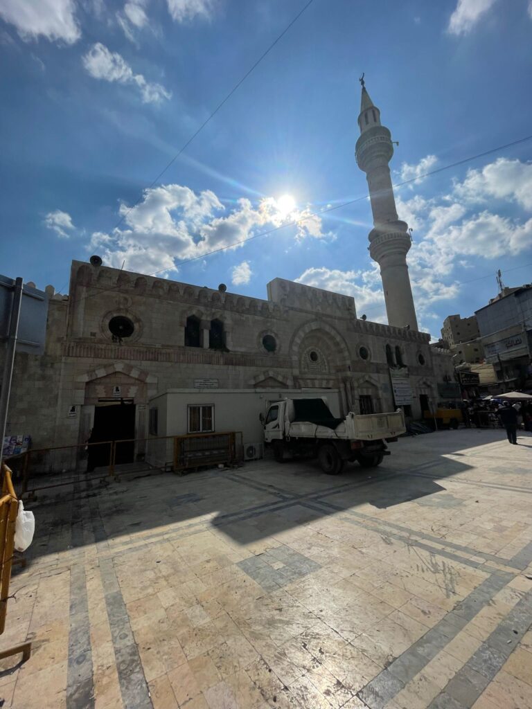 The Grand Husseini Mosque in Amman, Jordan, with the morning sun shining in the background