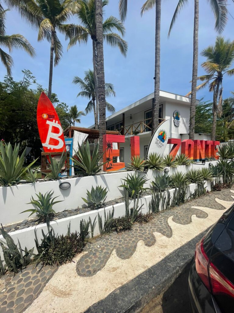 A sign that says "El Zonte" alongside the Bitcoin logo. El Zonte is a beach in El Salvador where locals are trying to establish one of the world's first cryptocurrency hubs. It is known as "Bitcoin Beach"