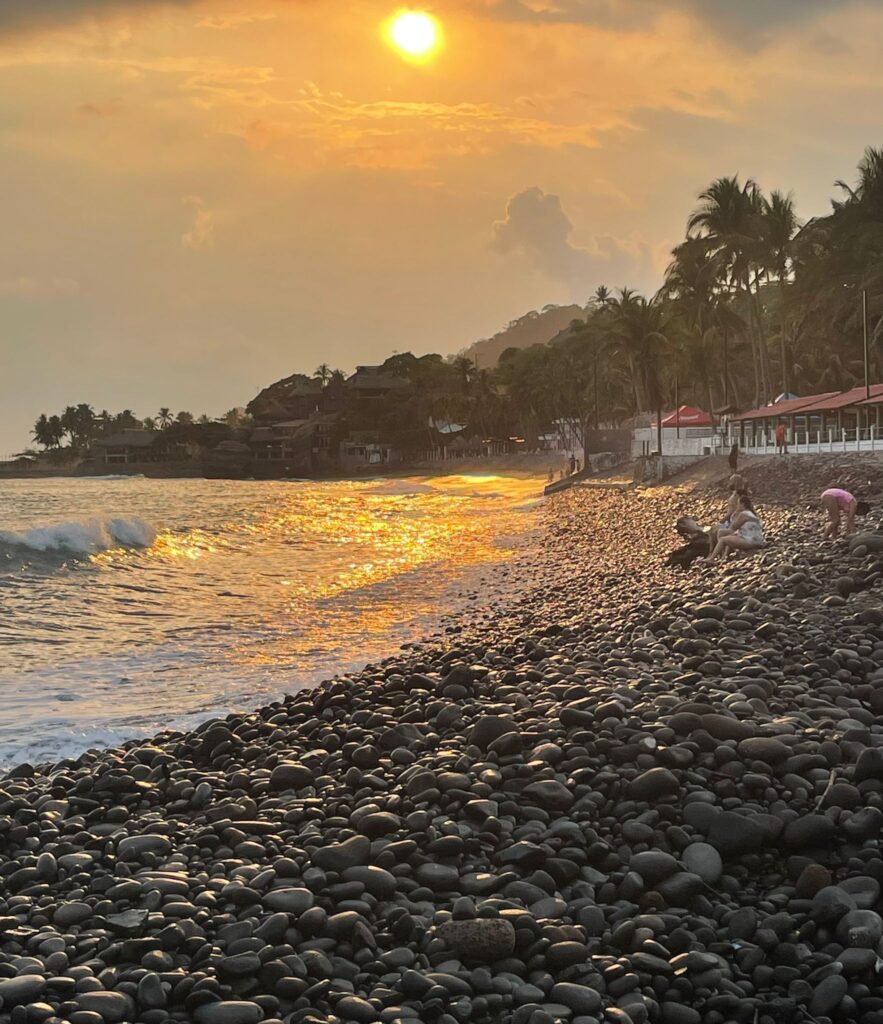 The sun setting as the waves come in towards the pebbles which make up El Tunco beach in El Salvador