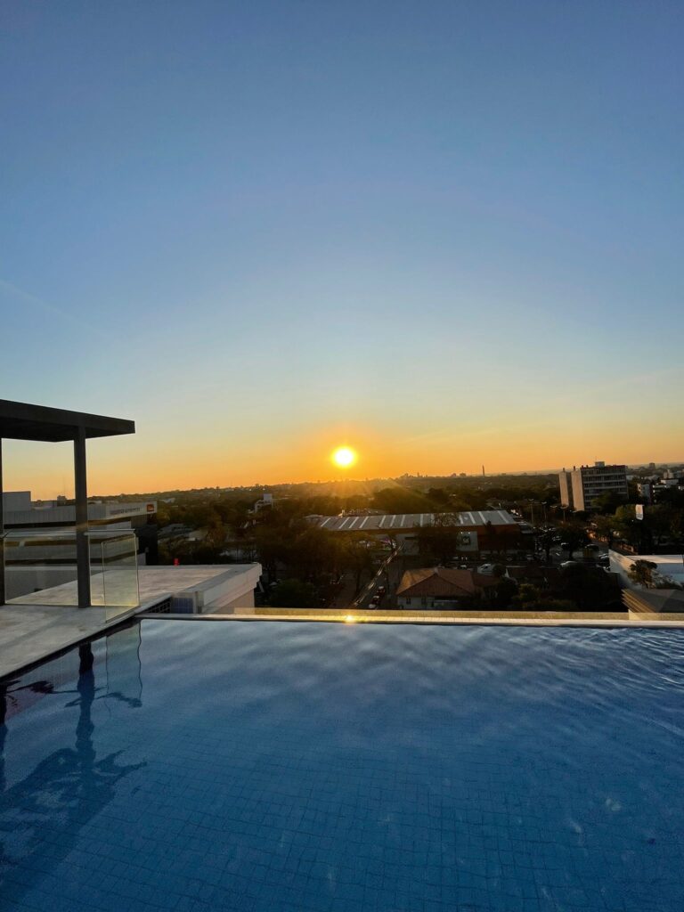 The sun setting over Asuncion in Paraguay, as seen from a rooftop with a swimming pool