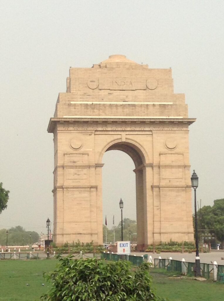 India Gate in New Delhi. This giant yellowish war memorial is shaped like a giant arch with the word 