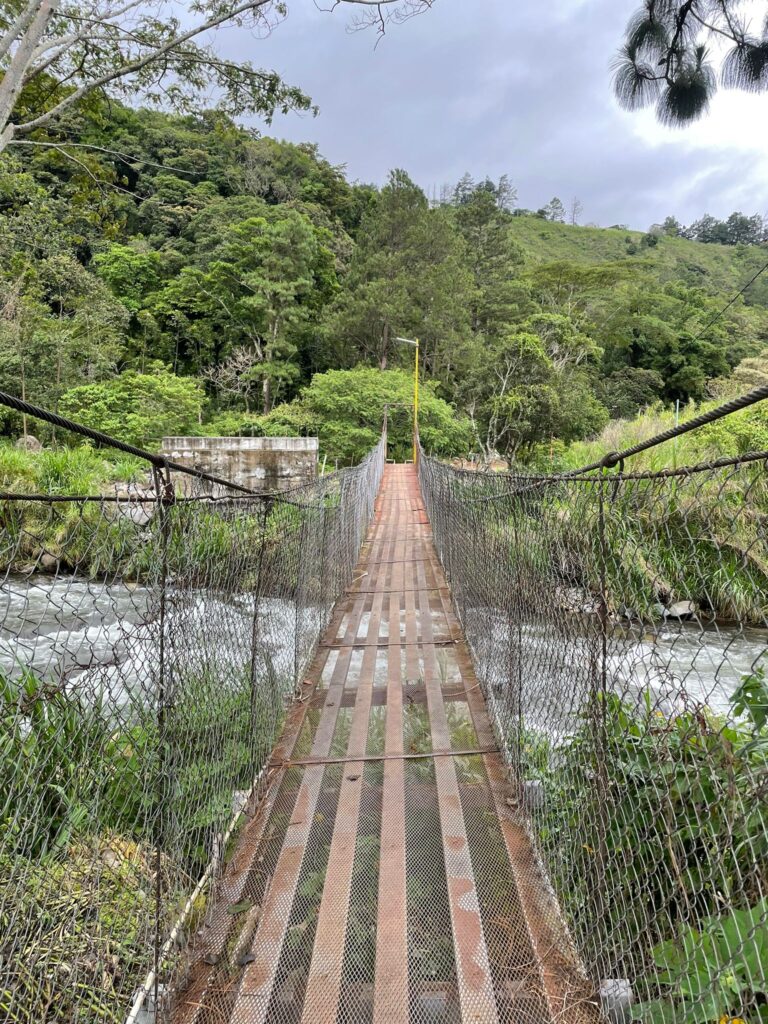 A hanging wooden bridge over a fast-flowing river in Boquete, Panama