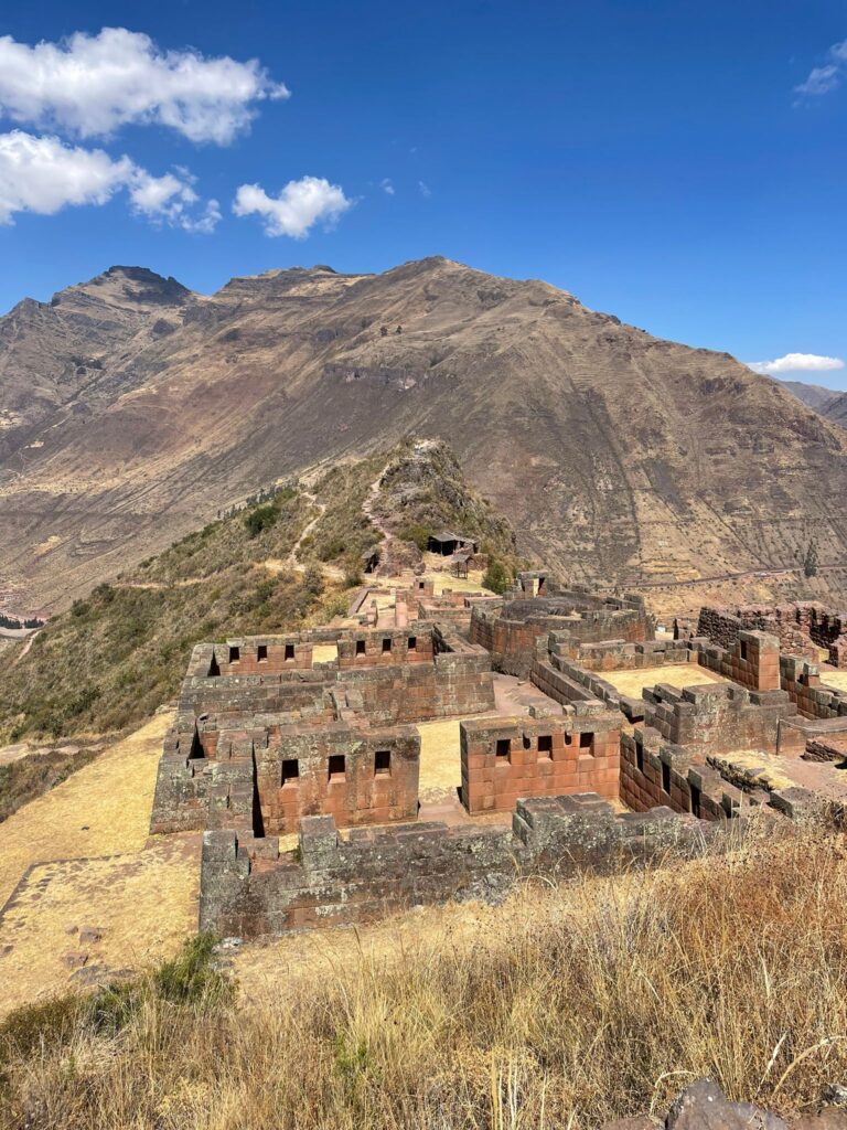 A series of Inca ruins at Pisac in Peru, with the mountains surrounding them in the background