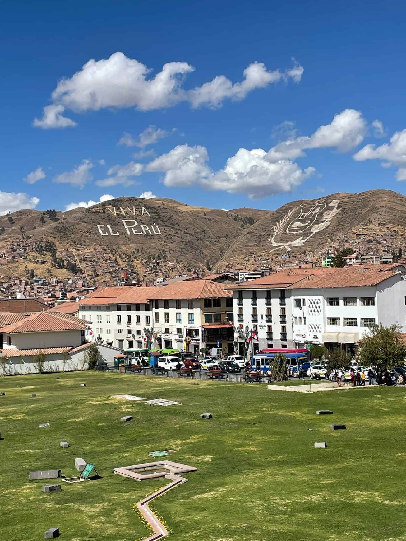 Geoglyphs are visible in the mountains surrounding these buildings in the popular city of Cusco, Peru.