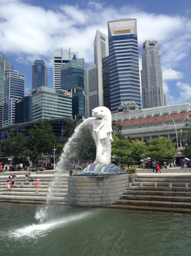 An image of the merlion statue in Singapore, with several skyscrapers visible in the background