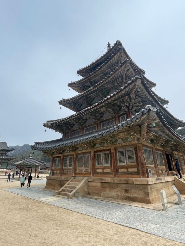 The 5-story Palsangjeon building at Beopjusa Temple. It is a typical Buddhist pagoda with each layer slightly smaller than the one below. The mountains can be seen in the background