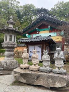Four small stone Buddha statues on a rock at Daegu's Donghwasa Temple, one of the most enjoyable places for solo travel in South Korea