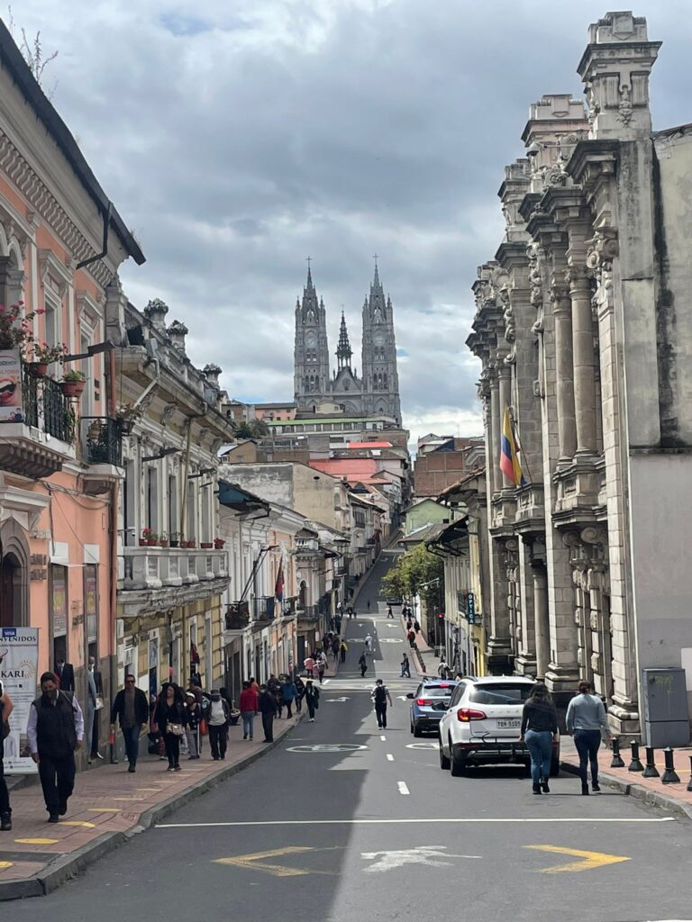 The hilly streets of Quito, with a large cathedral visible in the distance