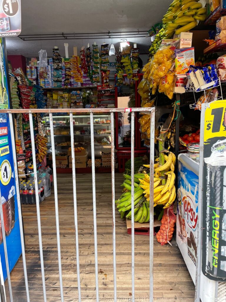 A small convenience store in Quito, Ecuador, with a barred gate at the entrance to act as a partial deterrent to thieves