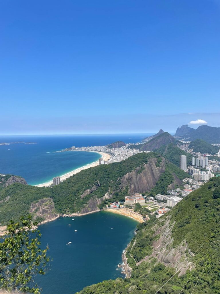 Aerial views of Rio de Janeiro in Brazil, with blue waters, yellow beaches and green trees covering the grey mountains