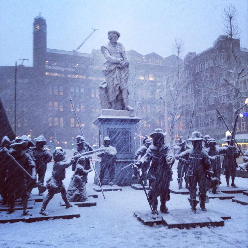 A series of statues in Amsterdam covered in snow