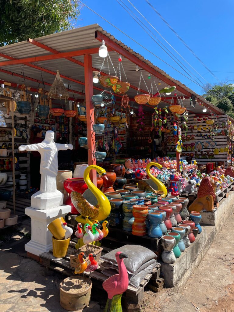 A series of ceramics including Christ the Redeemer, yellow flamingoes, small ducks, pots and a giant lion at Aregua in Paraguay