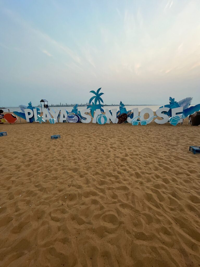 A yellow-sand beach in Encarnacion with the name "Playa San Jose" in big white letters