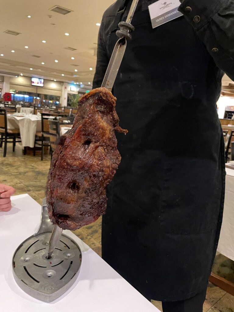 A waiter in Paulista Grill, Asuncion, bringing meat over to the table to be served