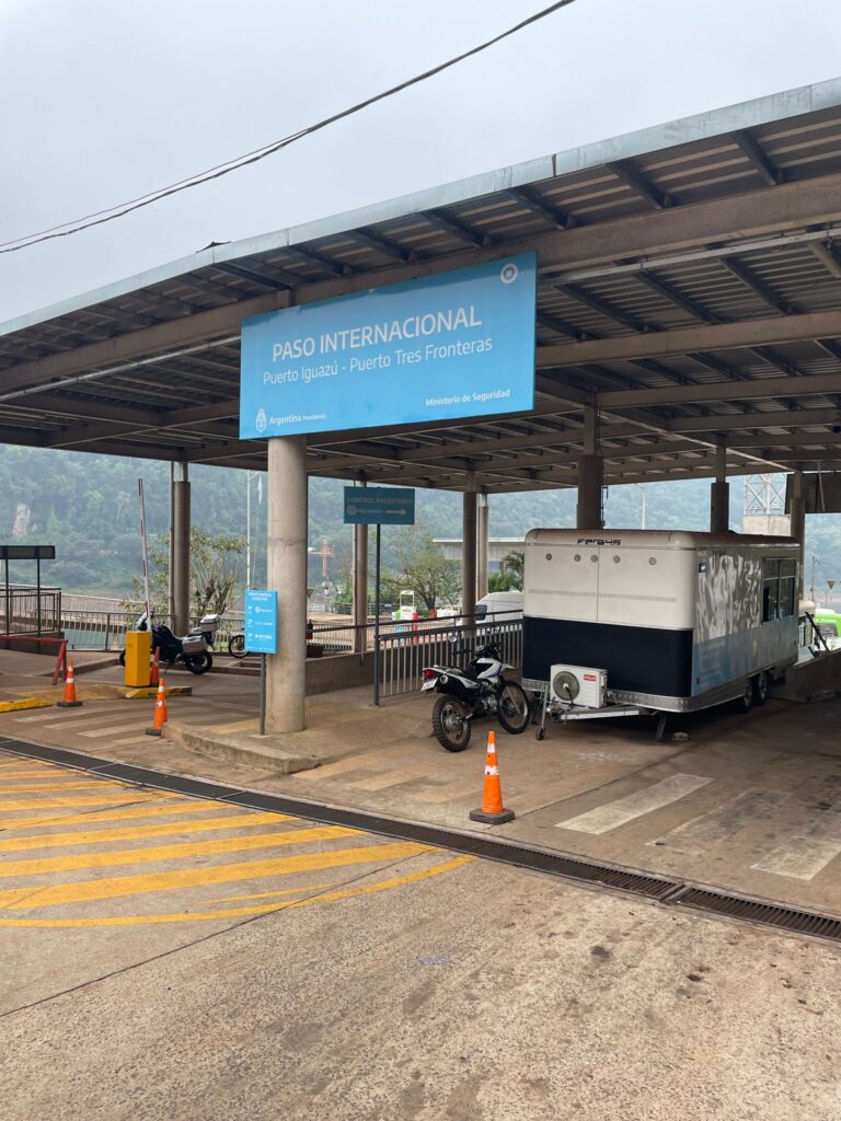 The ferry terminal in Puerto Iguazu, Argentina. It says "Paso Internacional: Puerto Iguazu - Puerto Tres Fronteras" on a blue sign above