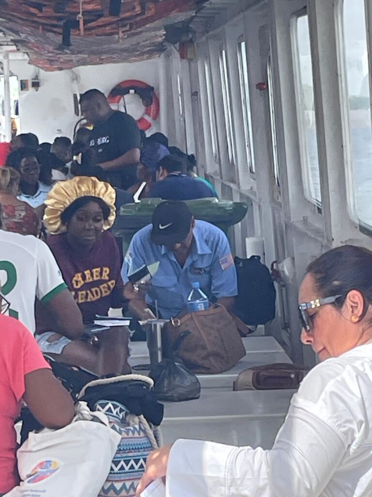 A group of passengers sit on the baking hot boat that travels between small border outposts connecting Suriname and Guyana