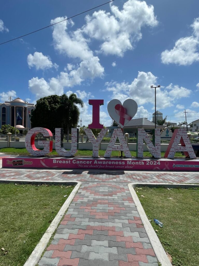 The "I Love Guyana" sign in the country's capital, Georgetown. The sign is pink and white in this image as it is raising awareness for Breast Cancer Awareness Month