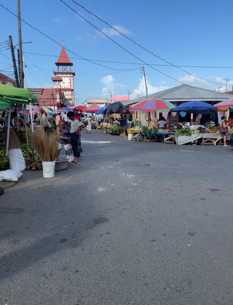 Brightly-coloured fruit stalls at Georgetown's Stabroek Market, with its iconic red and white clocktower in the background