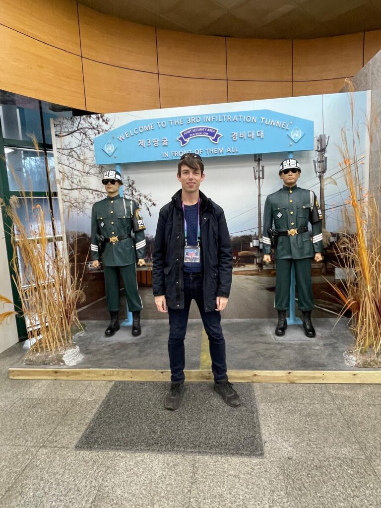 A picture of myself at the 3rd Infiltration Tunnel on South Korea's side of the DMZ. I am stood between two models of Korean soldiers wearing sunglasses as they guard an image of the JSA