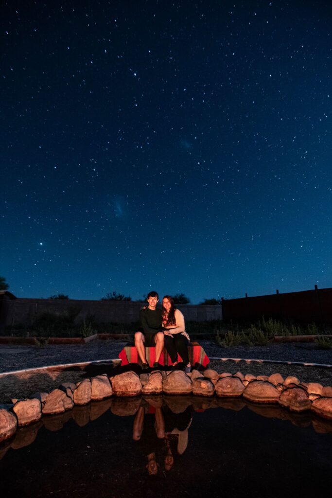 Myself and my girlfriend sitting on a bench in the Atacama Desert as the stars surround us in the background. This picture was taken during an astronomical tour we took