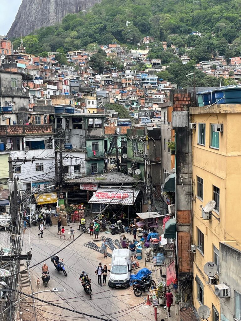 Street life in Favela Rocinha, Rio de Janeiro. Locals are shopping at street stalls and walking around the favela.